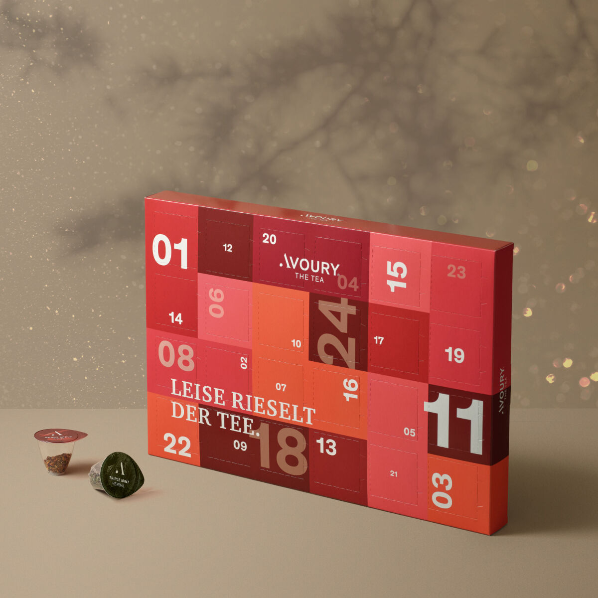 advent calendar with 24 doors designed in different shades of coulorful red in a retangular  box