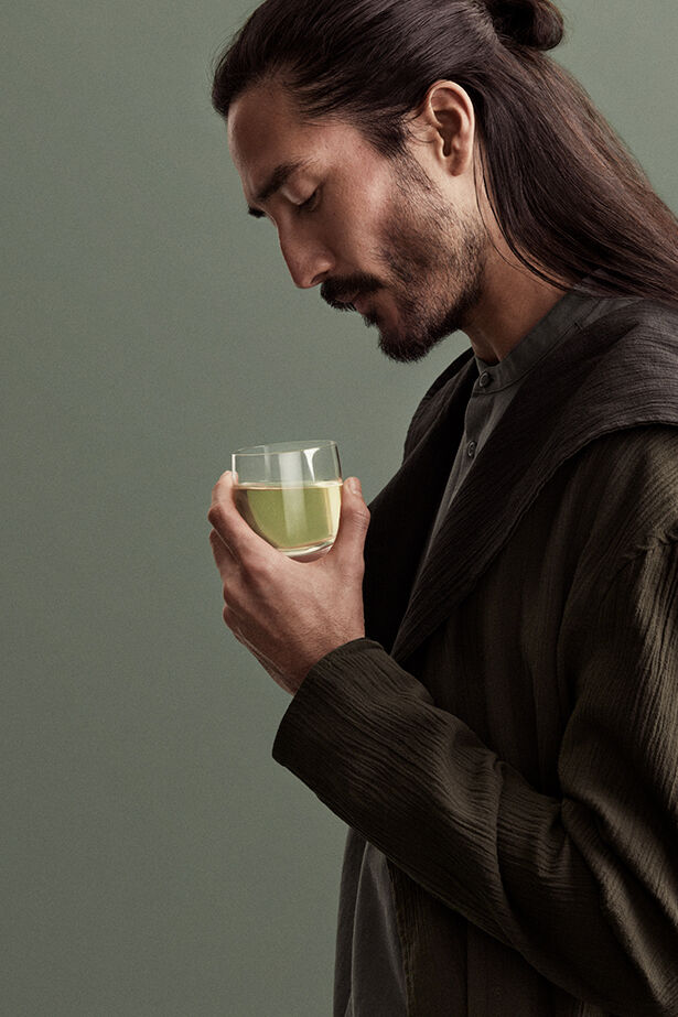 Mann hält eine Tasse grünen Tee